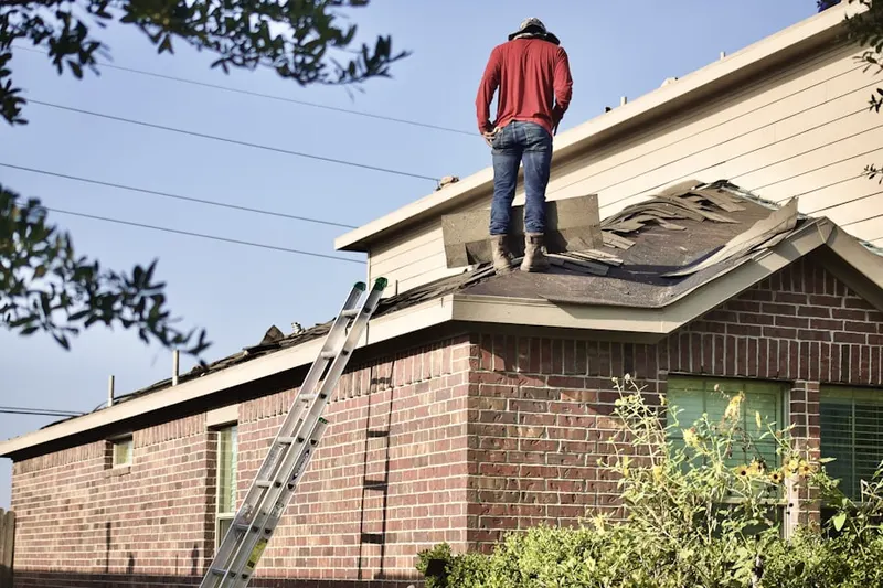 Professional roofer working on a residential roof in Schenck
